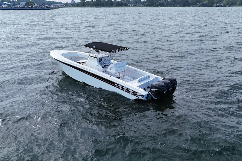 Slide: The Image of 2005 Fountain 34 Sportfish CC Open Bow boat on open water, featuring twin Mercury engines. - 3