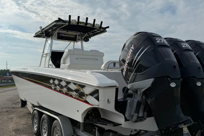Slide: The Image of 2005 Fountain 34 Sportfish CC Open Bow with triple Mercury engines, parked on a trailer. - 43