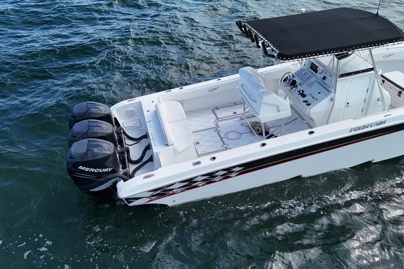 Slide: The Image of 2005 Fountain 34 Sportfish CC Open Bow boat with triple Mercury engines on water. - 9