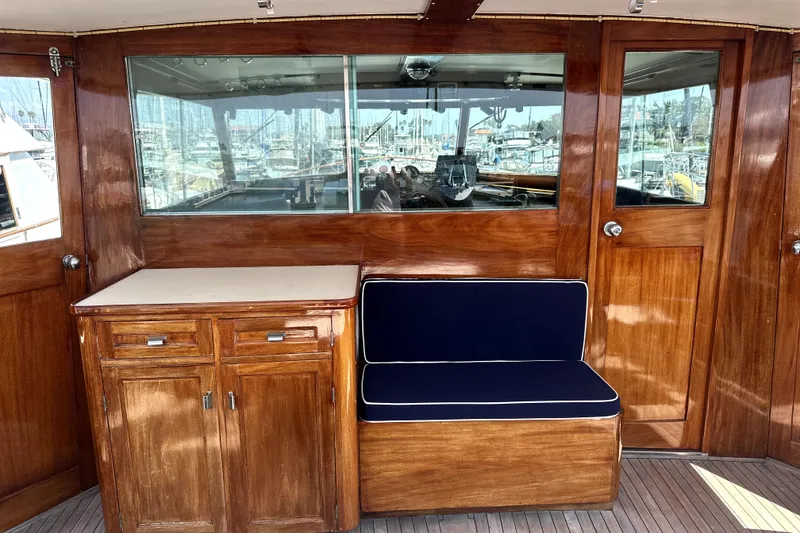 Slide: The Image of 1969 Stephens Brothers flush deck motor yacht interior with wooden cabinetry and navy seating. - 10