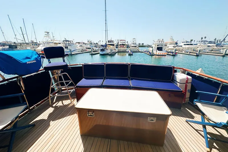 Slide: The Image of 1969 Stephens Brothers flush deck motor yacht with blue seating, docked in a marina. - 12