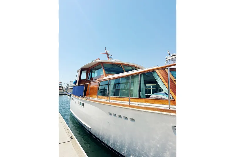 Slide: The Image of 1969 Stephens Brothers flush deck motor yacht docked under clear blue sky. - 2