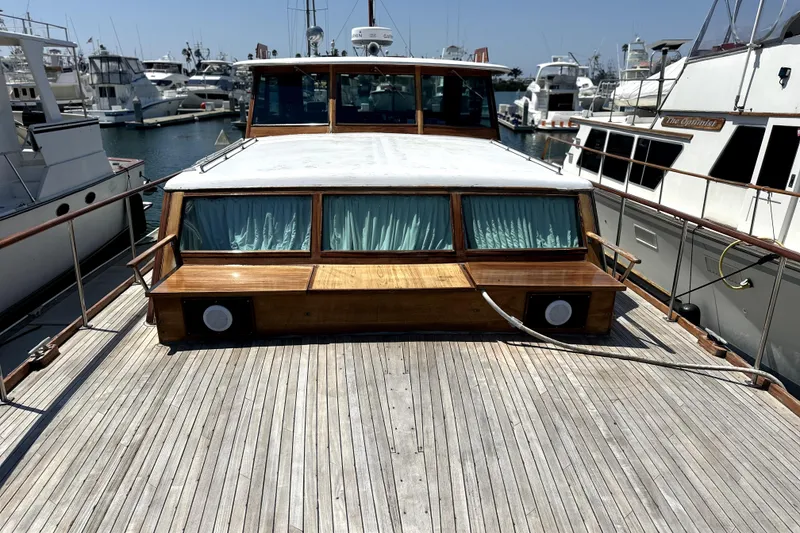Slide: The Image of 1969 Stephens Brothers flush deck motor yacht docked at marina, showcasing wooden deck and cabin. - 3