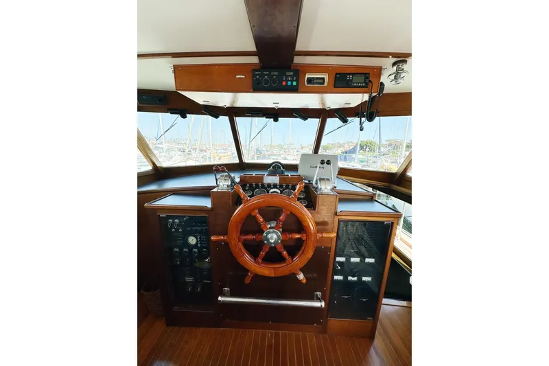 Slide: The Image of 1969 Stephens Brothers flush deck motor yacht helm with wooden steering wheel and control panel. - 36