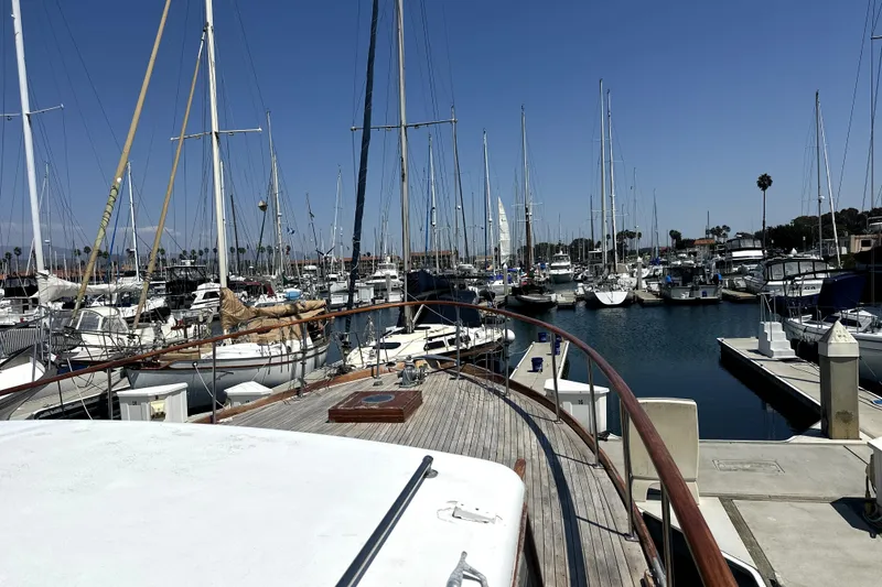 Slide: The Image of 1969 Stephens Brothers flush deck motor yacht docked in a marina with sailboats. - 4
