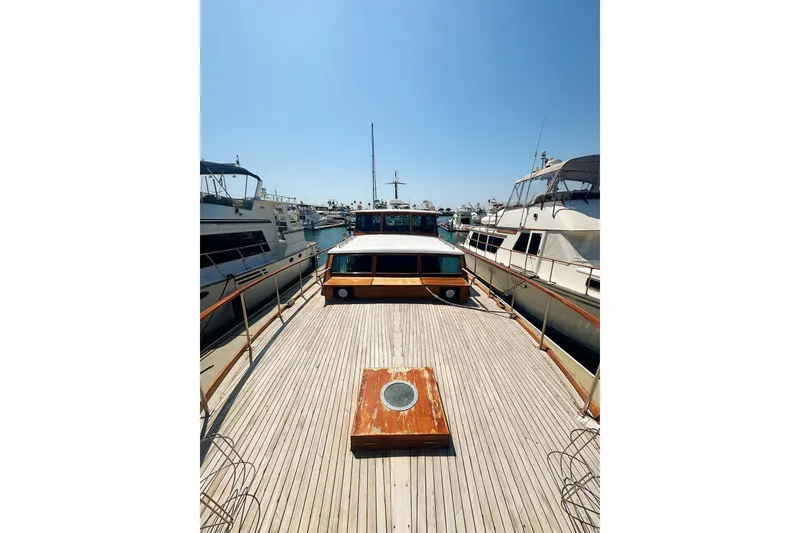 Slide: The Image of 1969 Stephens Brothers flush deck motor yacht docked in a marina under clear skies. - 8