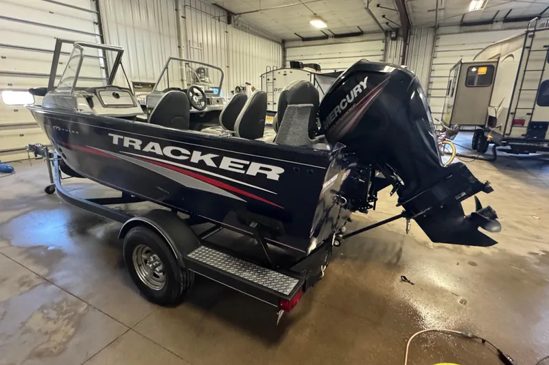 Slide: The Image of 2019 Tracker Pro Guide V-175 Combo boat with Mercury engine in a garage setting. - 5
