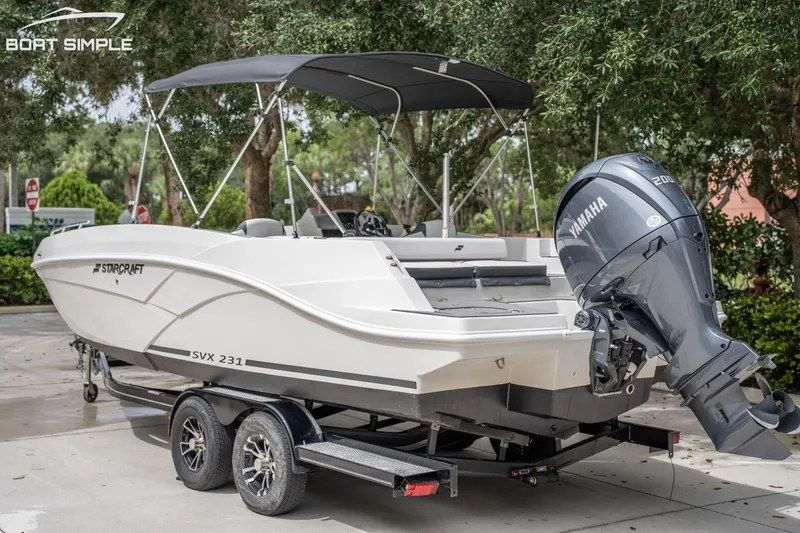 Slide: The Image of 2023 Starcraft SVX 231 OB DH boat with Yamaha engine on trailer, parked outdoors. - 7