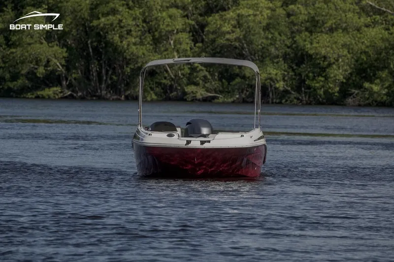 Slide: The Image of 2023 Hurricane SunDeck Sport 205 OB boat on a serene lake. - 2