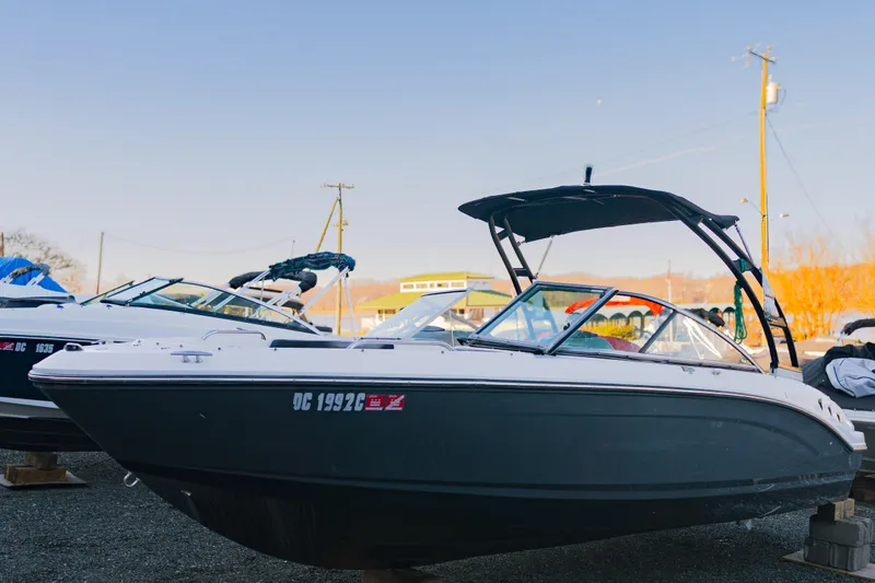 Slide: The Image of 2018 Chaparral 210 Suncoast boat displayed outdoors on a sunny day. - 0
