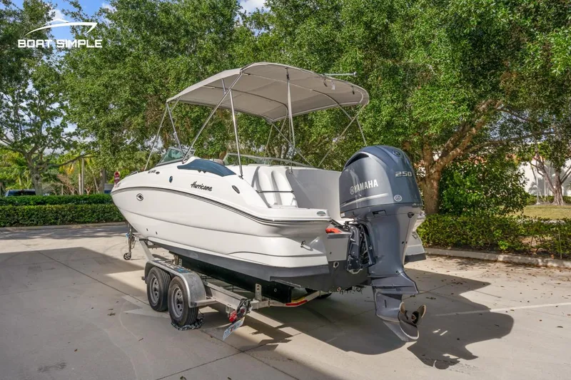 Slide: The Image of 2025 Hurricane SunDeck 2400 OB boat on trailer with Yamaha engine, parked outdoors. - 1