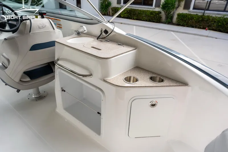Slide: The Image of 2025 Hurricane SunDeck 2400 OB boat interior with helm, sink, and storage compartments. - 11