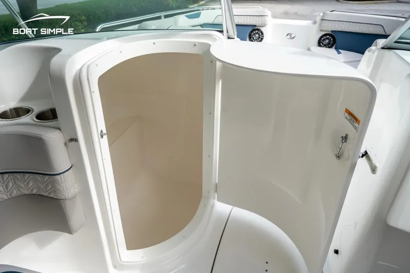 Slide: The Image of 2025 Hurricane SunDeck 2400 OB boat interior with open storage compartment and cup holders. - 9