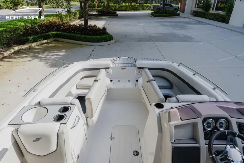 Slide: The Image of 2023 Starcraft SVX 211 OB boat interior with seating and dashboard, parked outdoors. - 9