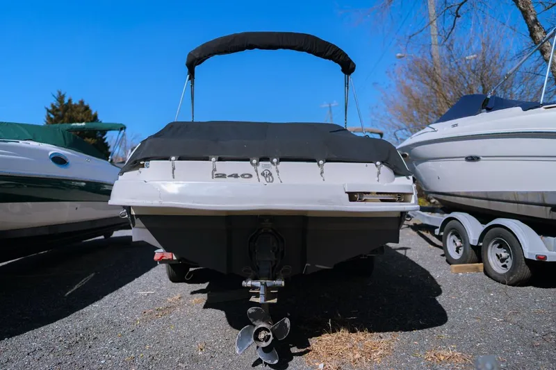 Slide: The Image of 2012 Sea Ray 240 Sundeck boat on trailer, rear view, parked outdoors. - 1