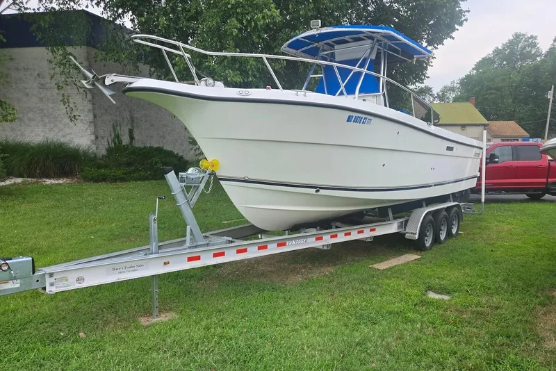 The Image of 2001 Shamrock 270 Open boat on trailer, parked on grass, with a red truck nearby. - 0