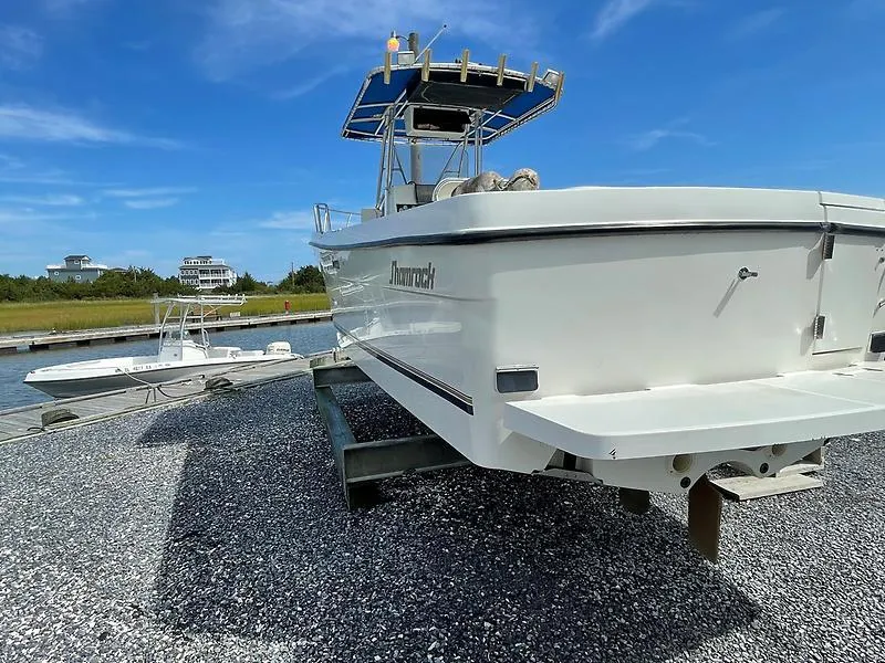 Slide: The Image of 2001 Shamrock 270 Open boat on trailer, clear sky, waterfront background. - 11