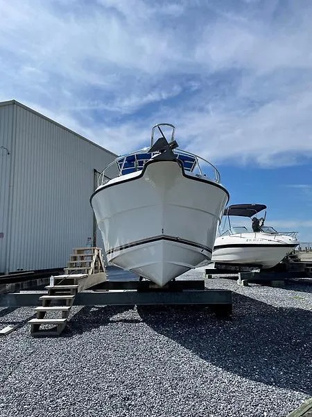 Slide: The Image of 2001 Shamrock 270 Open boat on gravel, clear sky background. - 14