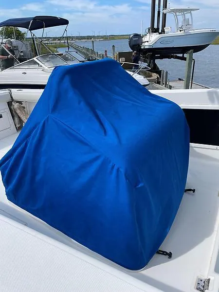 Slide: The Image of 2001 Shamrock 270 Open boat with blue cover on deck, docked by the water. - 27