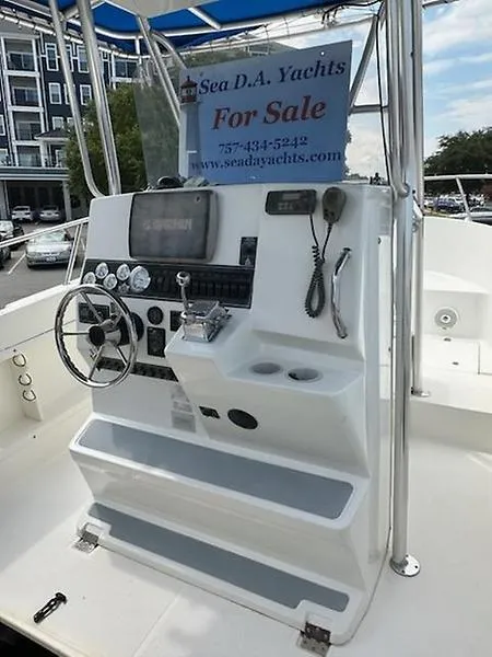 Slide: The Image of 2001 Shamrock 270 Open boat dashboard with steering wheel and controls, for sale sign displayed. - 9