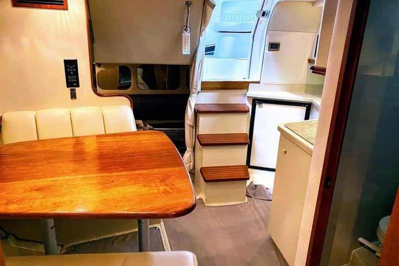 Slide: The Image of Interior of 2001 Cruisers Yachts 3470 Express, featuring elegant wood finishes and cozy seating. - 4