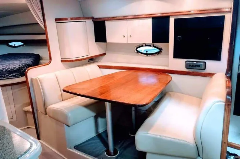 Slide: The Image of Interior of 2001 Cruisers Yachts 3470 Express, featuring dining area and compact kitchen. - 5