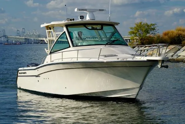 Slide: The Image of 2016 Grady-White Express 330 boat on water, clear sky, bridge in background. - 3