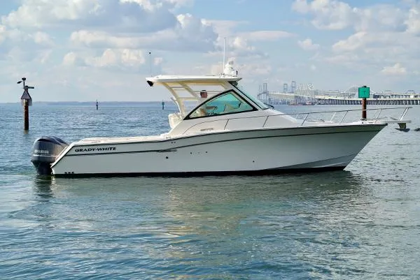 Slide: The Image of 2016 Grady-White Express 330 boat on calm water with a scenic background. - 4