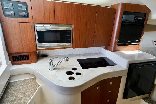 Slide: The Image of 2016 Grady-White Express 330 kitchen with wood cabinets, microwave, stove, and sink. - 40