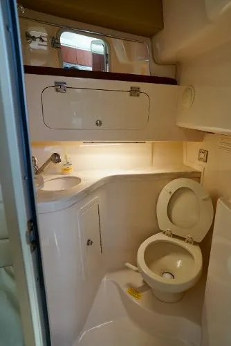 Slide: The Image of 2016 Grady-White Express 330 boat bathroom with sink, toilet, and storage cabinet. - 44