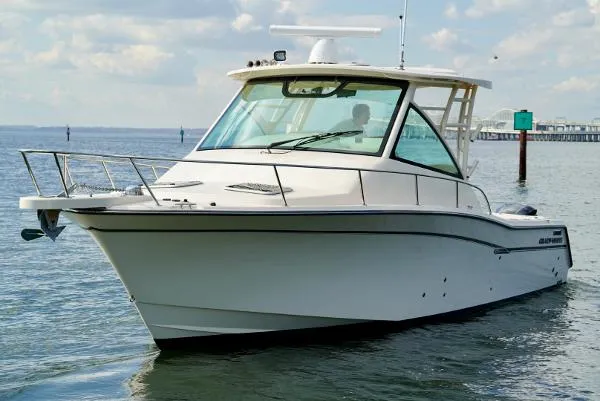 Slide: The Image of 2016 Grady-White Express 330 boat on calm water, showcasing sleek design and spacious cabin. - 5