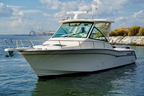 Slide: The Image of 2016 Grady-White Express 330 boat on calm water near rocky shoreline. - 6