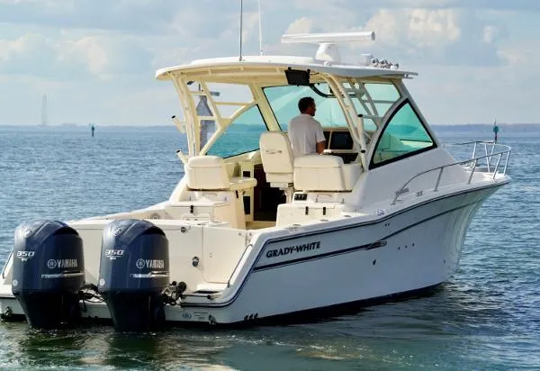Slide: The Image of 2016 Grady-White Express 330 boat docked with Yamaha engines, clear sky background. - 8