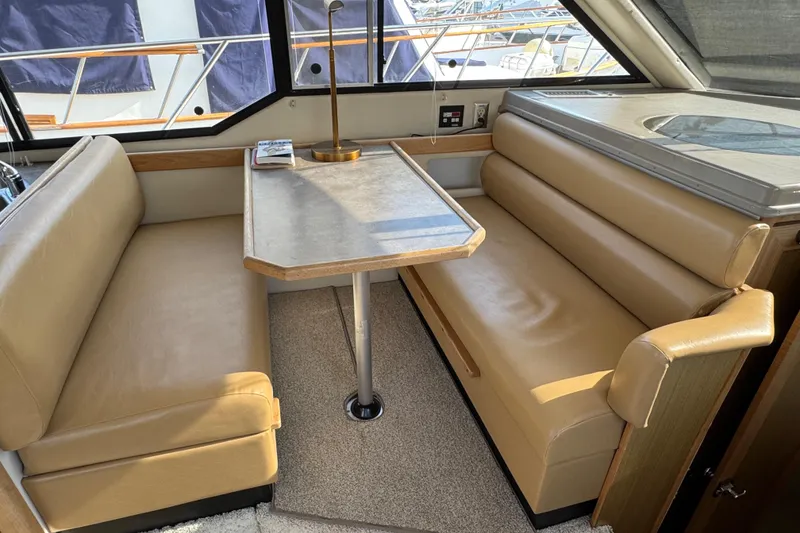 Slide: The Image of 2001 Bayliner 4087 Aft Cabin Motoryacht interior with beige seating and dining table. - 16