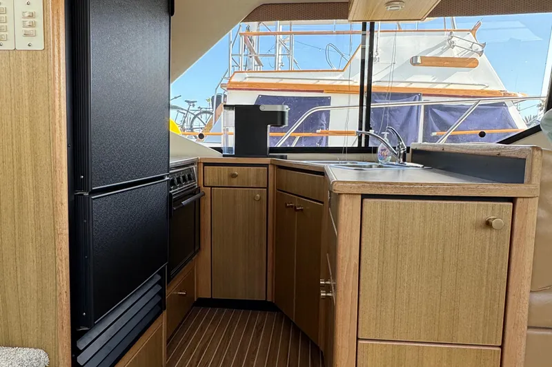 Slide: The Image of 2001 Bayliner 4087 Aft Cabin Motoryacht kitchen interior with wood cabinetry and appliances. - 19