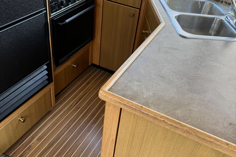 Slide: The Image of 2001 Bayliner 4087 Aft Cabin Motoryacht kitchen with wood cabinetry and stainless steel sink. - 20