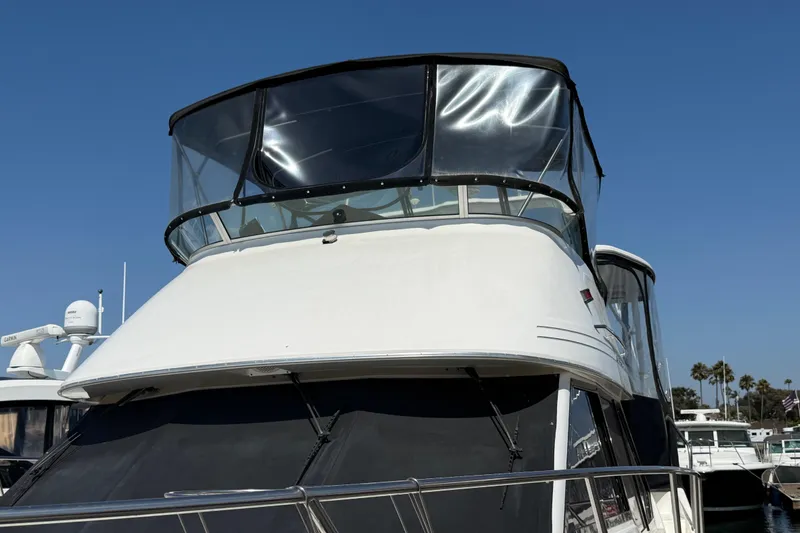 Slide: The Image of 2001 Bayliner 4087 Aft Cabin Motoryacht with clear canopy, docked under blue sky. - 4