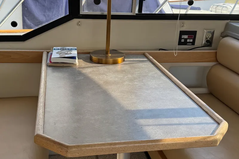 Slide: The Image of Interior of 2001 Bayliner 4087 yacht with table, lamp, and book by window. - 43