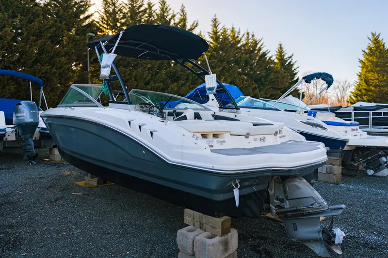 Slide: The Image of 2018 Chaparral 210 Suncoast boat on display, parked on blocks, surrounded by trees. - 8