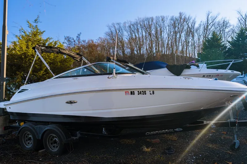 Slide: The Image of 2015 Sea Ray 220 Sundeck boat on trailer, parked outdoors. - 0