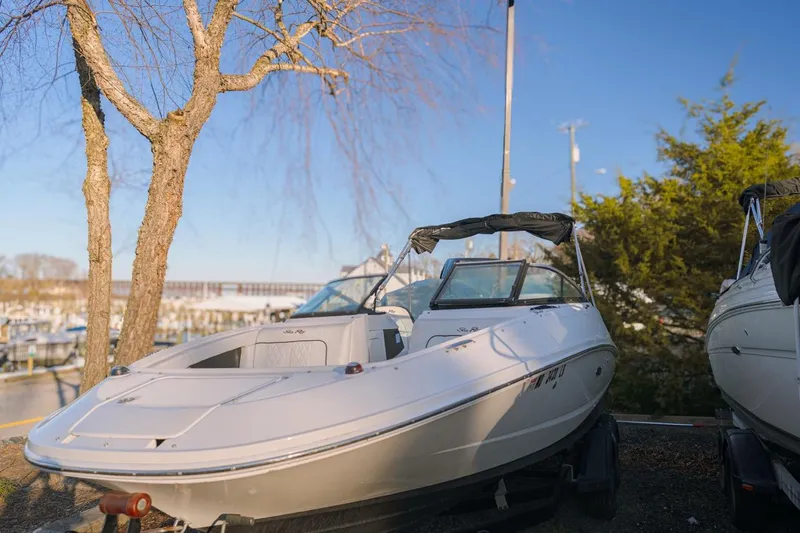 Slide: The Image of 2015 Sea Ray 220 Sundeck boat parked near marina, sunny day. - 1
