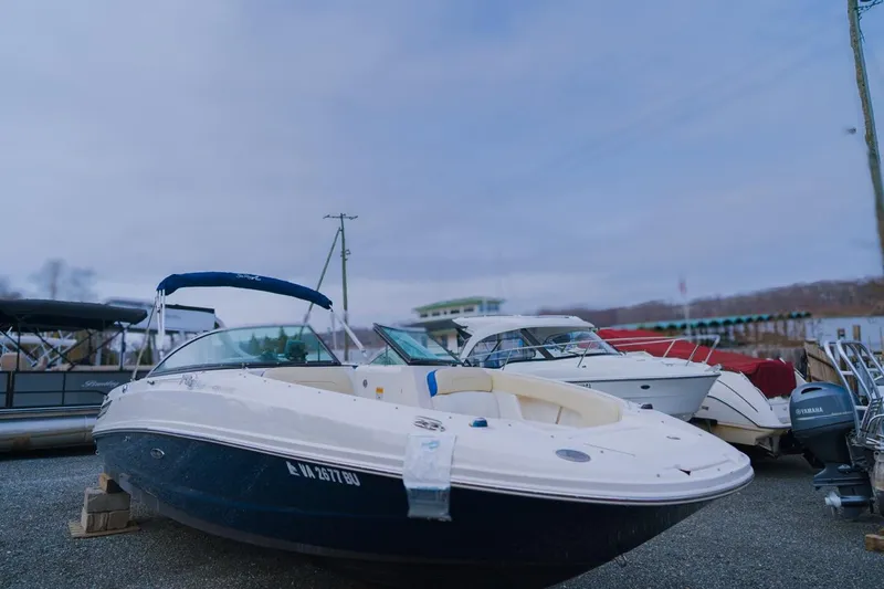 Slide: The Image of 2013 Sea Ray 240 Sundancer boat docked in a marina, surrounded by other vessels. - 2