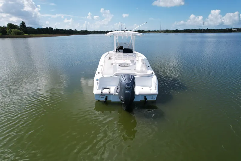 Slide: The Image of 2025 Sea Hunt Ultra 229 boat on calm water under a clear blue sky. - 1