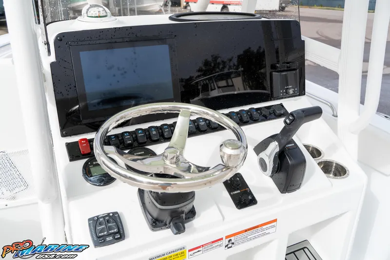 Slide: The Image of 2025 Sea Hunt Ultra 229 boat dashboard with steering wheel and controls. - 20