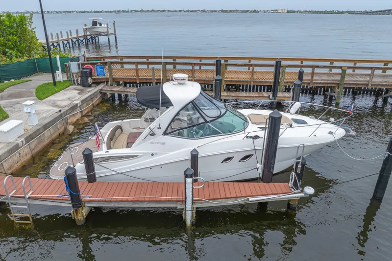 Slide: The Image of 2014 Sea Ray 330 Sundancer docked at marina with scenic waterfront view. - 1