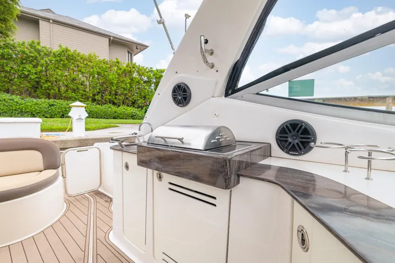 Slide: The Image of 2014 Sea Ray 330 Sundancer boat interior with grill and seating area. - 5