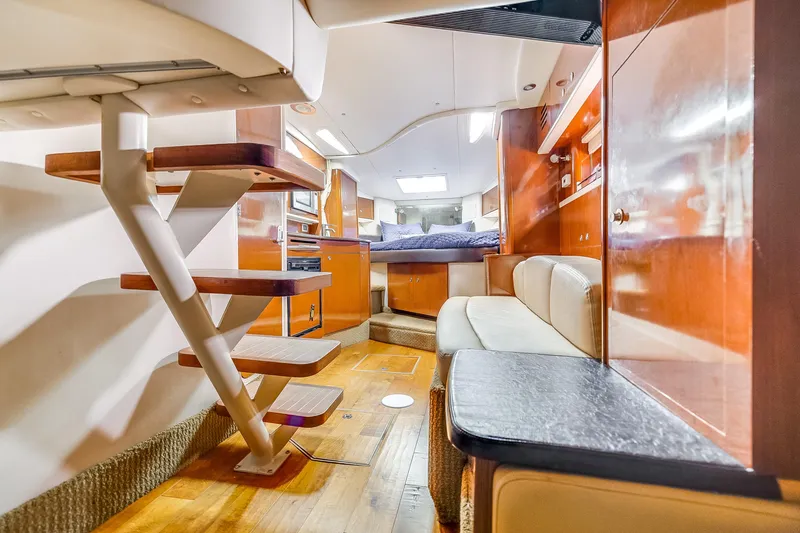 Slide: The Image of 2014 Sea Ray 330 Sundancer interior with wooden stairs, cozy seating, and modern amenities. - 8