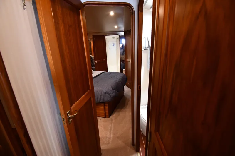 Slide: The Image of Interior of 1996 Ocean Yachts 53 Super Sport, featuring a cozy bedroom and wooden finishes. - 25