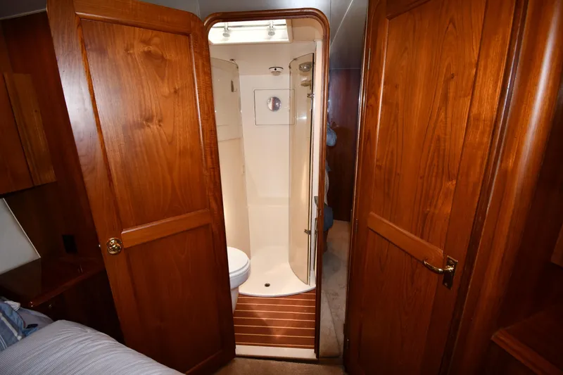 Slide: The Image of Interior of 1996 Ocean Yachts 53 Super Sport, featuring wooden doors and compact bathroom. - 29