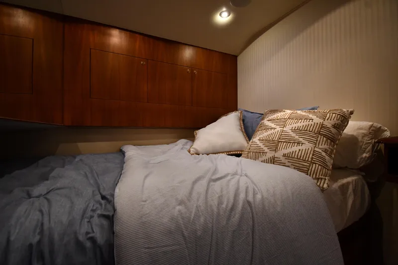 Slide: The Image of Cozy bedroom interior of 1996 Ocean Yachts 53 Super Sport with wooden cabinets and plush bedding. - 35